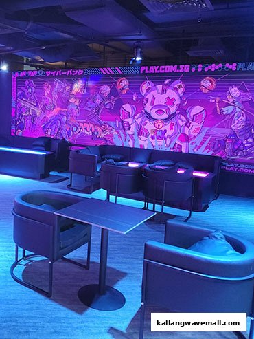 A futuristic lounge area with comfortable seating and vibrant neon-lit gaming-themed wall art.