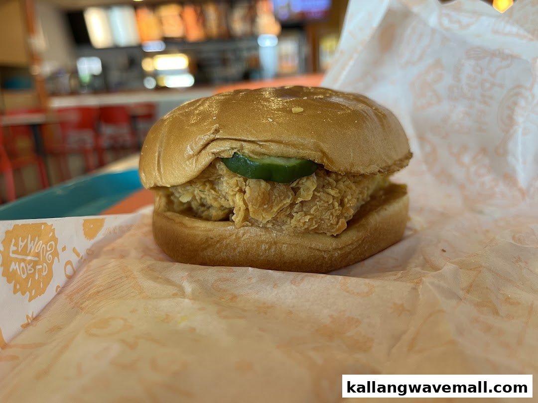 A delicious Popeyes fried chicken sandwich with pickles, ready to enjoy.