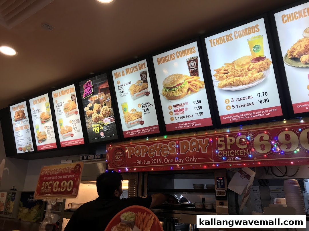 Digital menu boards at Popeyes showcasing various chicken, burger, and tender combos with prices.