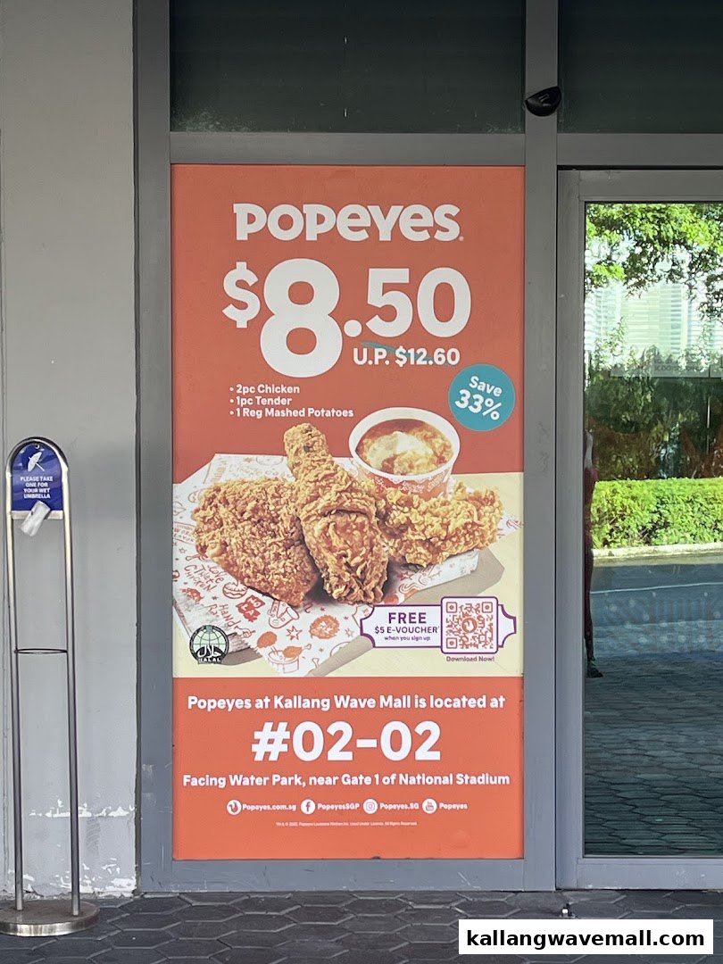 A Popeyes promotional poster at Kallang Wave Mall featuring a meal deal and location details.