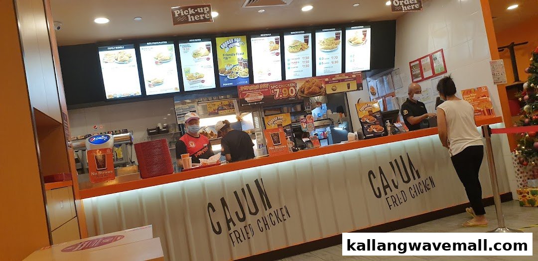 Interior view of Popeyes counter with prominent digital menu boards displaying various meal options.