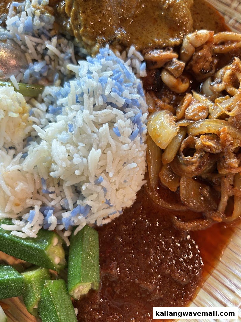 A close-up of Nasi Lemak with blue pea rice, chicken curry, sambal, and okra.