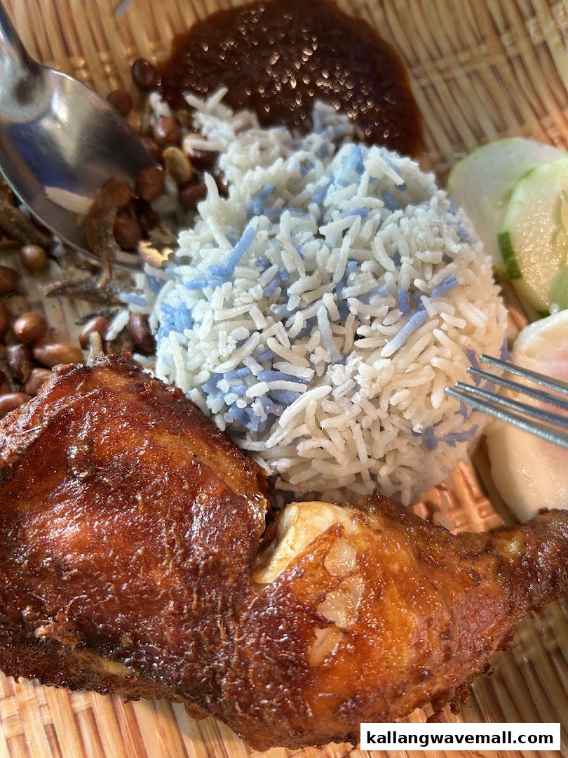 Delicious Nasi Lemak with blue rice, crispy fried chicken, sambal, and traditional accompaniments.