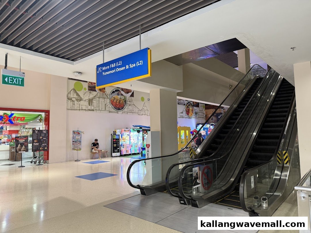 A mall corridor with escalators, an exit, and an entertainment area featuring arcade machines.