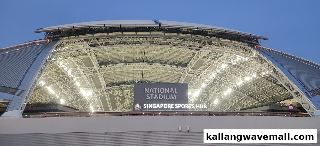 The illuminated roof and structure of the National Stadium, Singapore Sports Hub, at dusk.