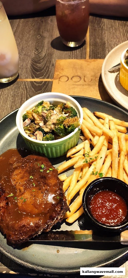 A delicious plate featuring meat with gravy, crispy fries, and a side of roasted broccoli.