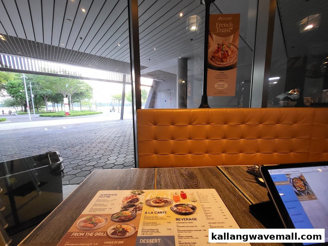Interior view of Poulet restaurant, showing a table with a menu, comfortable seating, and a scenic outdoor view.