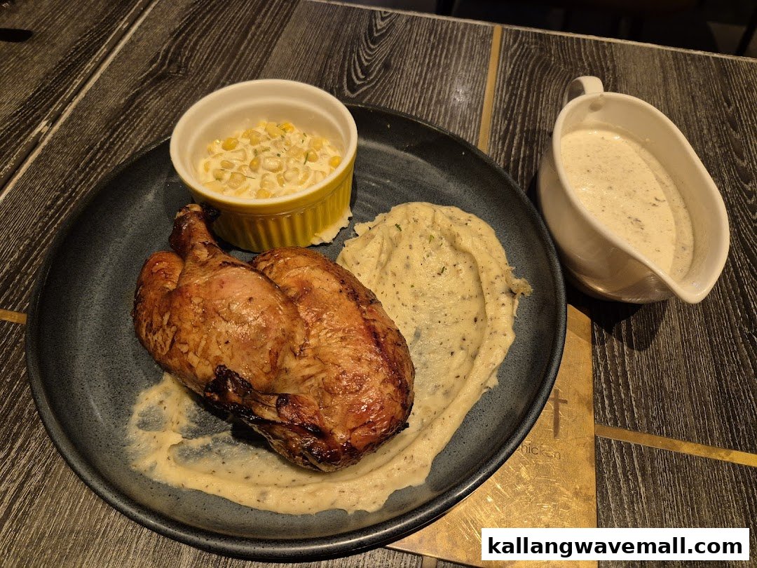 A delicious roasted chicken served with creamy mashed potatoes, corn, and a side of gravy.