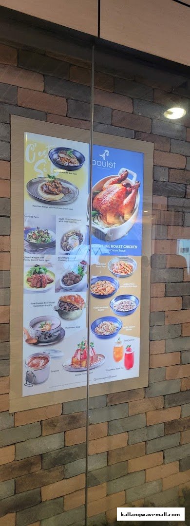 A digital menu display at Poulet, showcasing their signature roast chicken and a variety of French-inspired dishes.