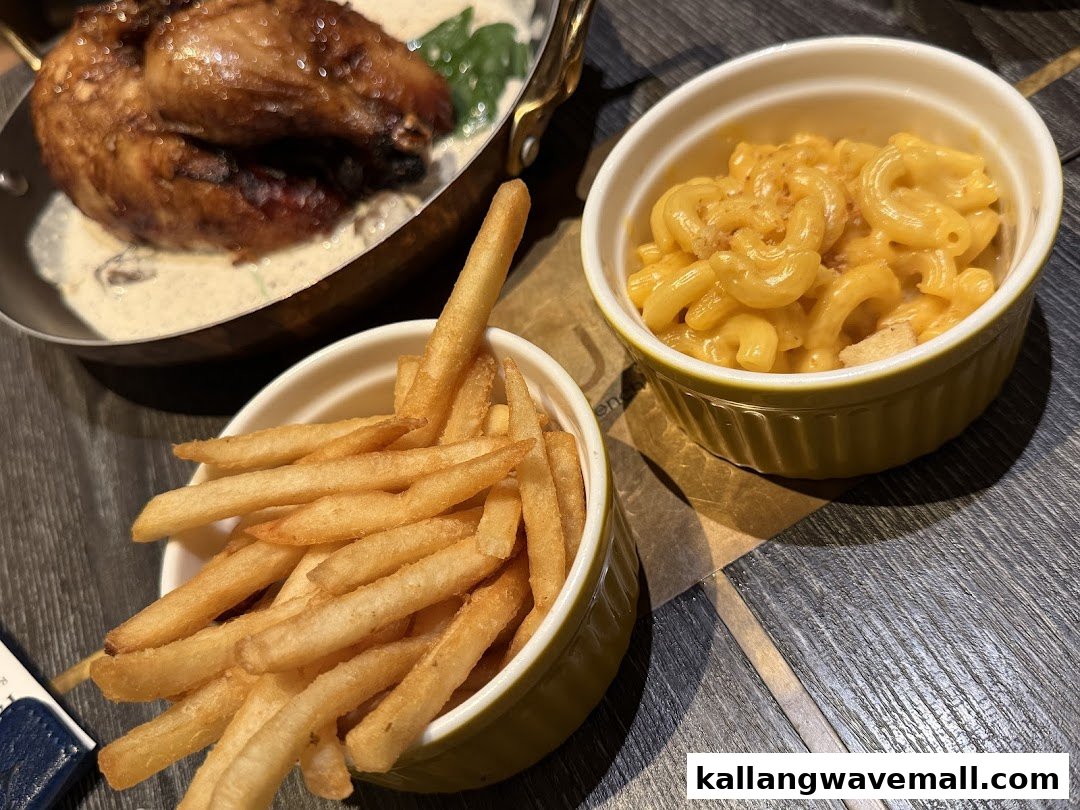 A delicious meal featuring roasted chicken, golden fries, and creamy mac and cheese.