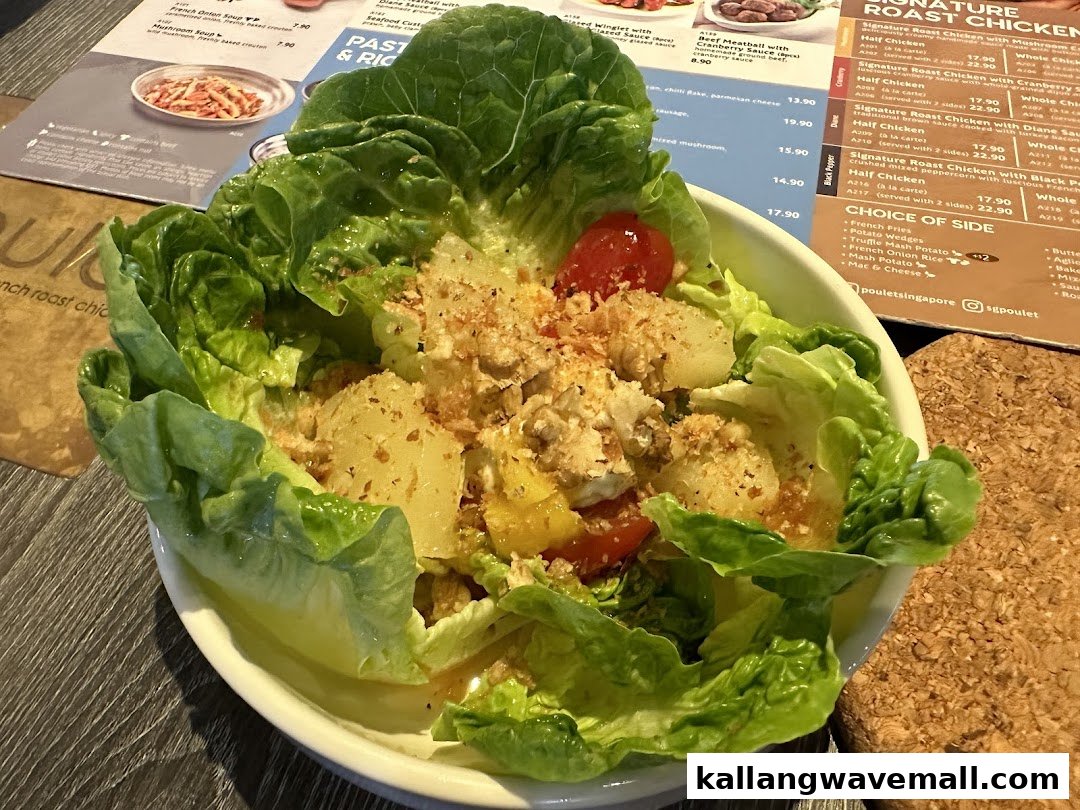 A close-up of a fresh salad with a restaurant menu displaying various dishes and prices in the background.