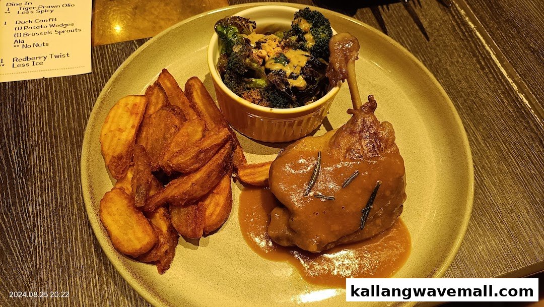 A delicious plate of Duck Confit with potato wedges and roasted broccoli from Poulet.