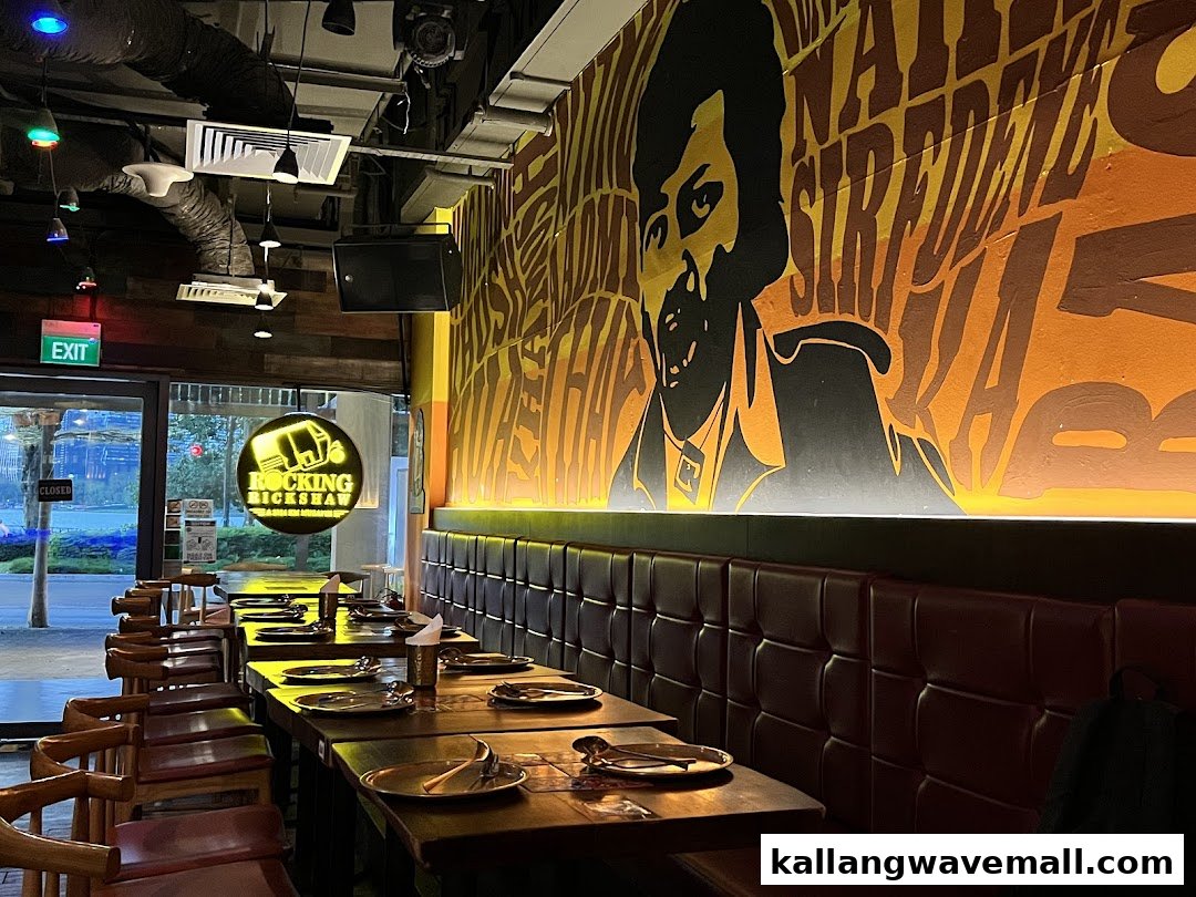 Interior view of Rocking Rickshaw restaurant with tables, booth seating, and a vibrant wall mural.