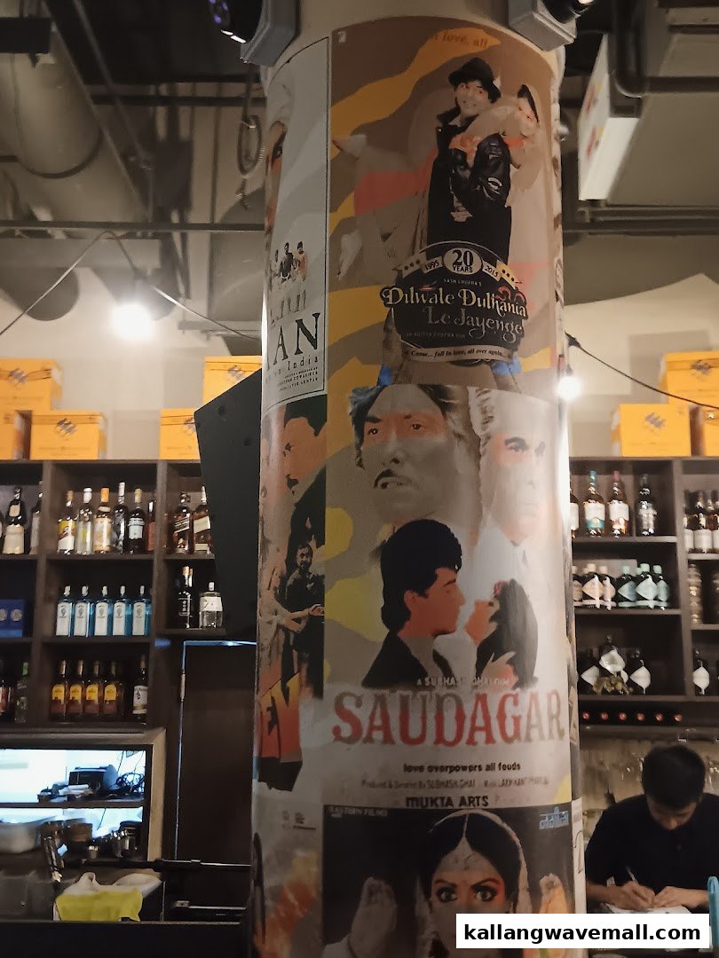 A decorative pillar adorned with classic Bollywood movie posters, showcasing the unique interior of Rocking Rickshaw.