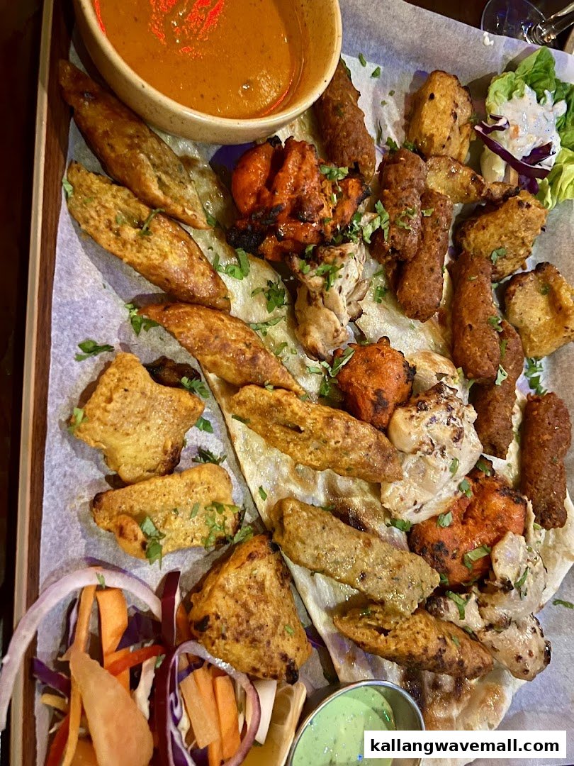 A vibrant platter of assorted Indian appetizers with dipping sauces and fresh salad.