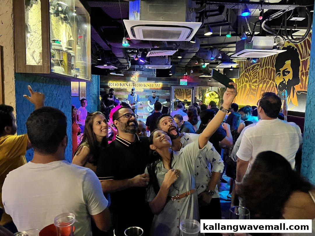 A vibrant interior shot of Rocking Rickshaw with a live band performing and cheerful patrons.