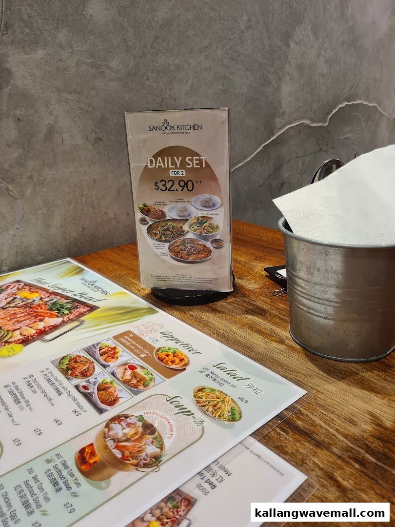 A table setting at Sanook Kitchen featuring a daily set menu standee and a flat menu with appetizers, salads, and soups.
