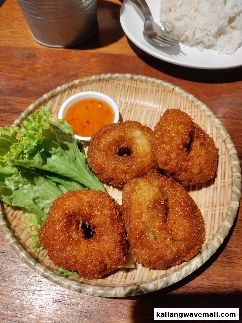 A plate of golden-fried shrimp cakes with fresh lettuce and sweet chili dipping sauce.