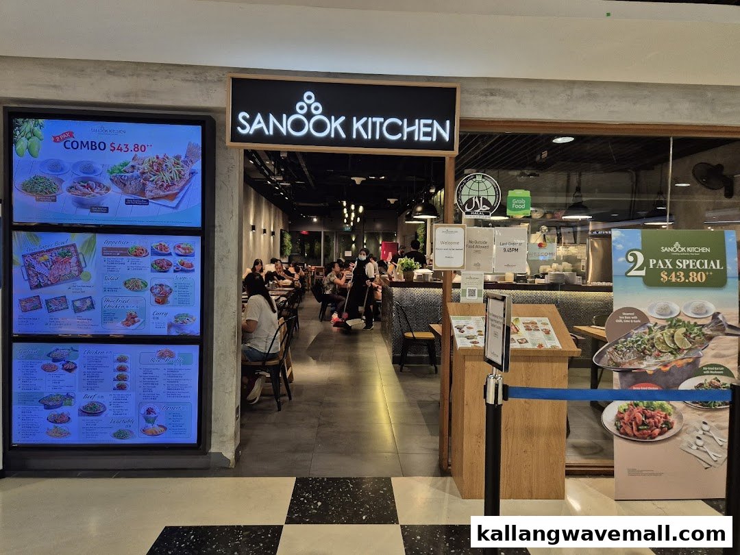 A vibrant Sanook Kitchen entrance featuring a large digital menu board showcasing Thai dishes and special offers.