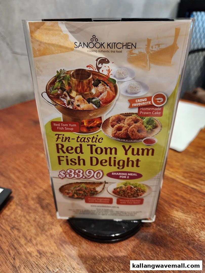 A table-top menu displaying Sanook Kitchen's 'Fin-tastic Red Tom Yum Fish Delight' sharing meal.
