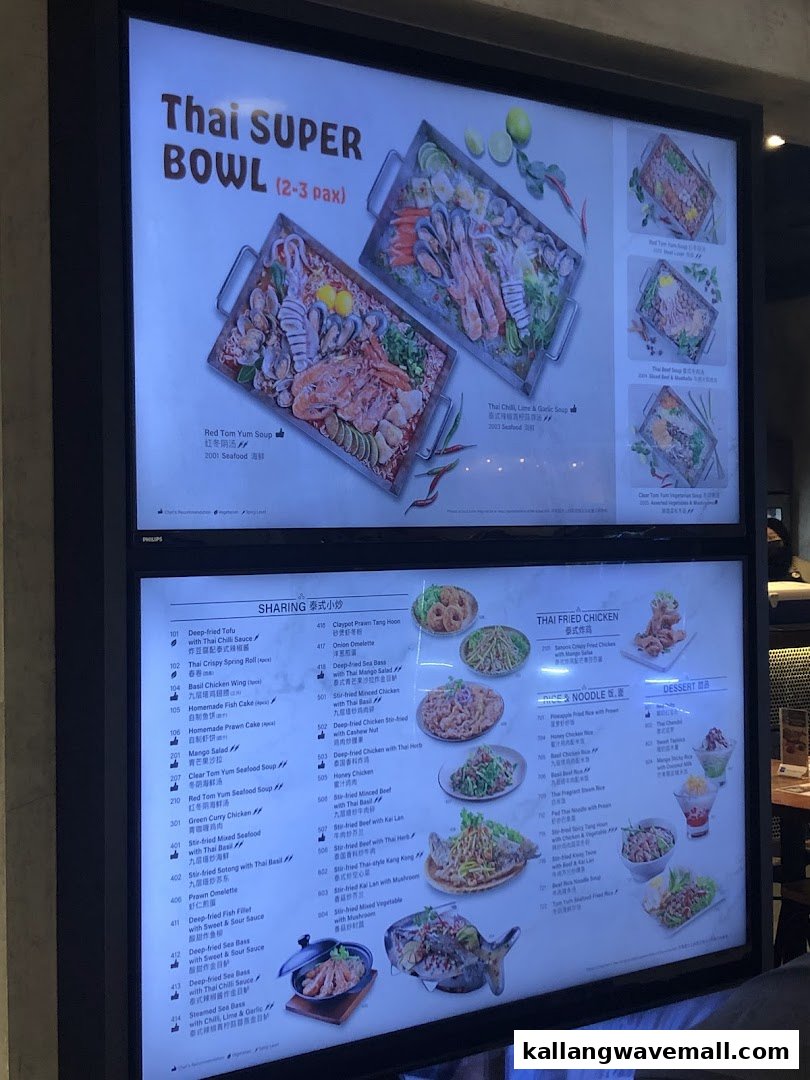 A brightly lit digital menu board showcasing a variety of Thai dishes and beverages.
