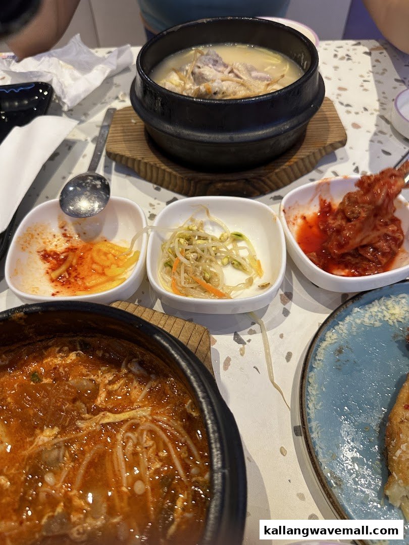 A table laden with delicious Korean dishes, including a hearty soup and various banchan.