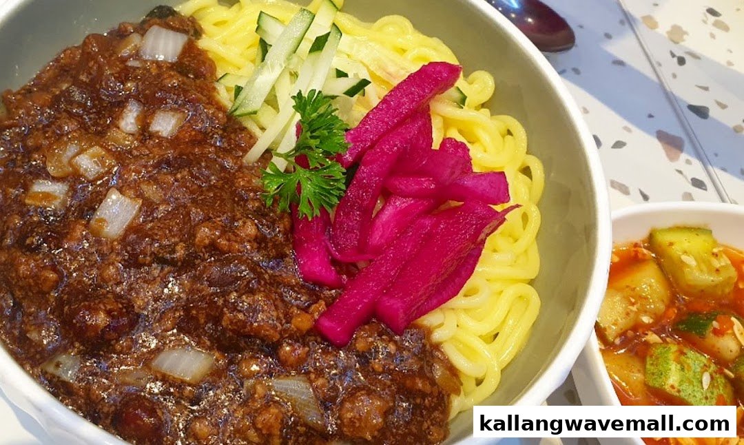 A close-up of Korean Jajangmyeon noodles with black bean sauce, pickled radish, and a side dish.