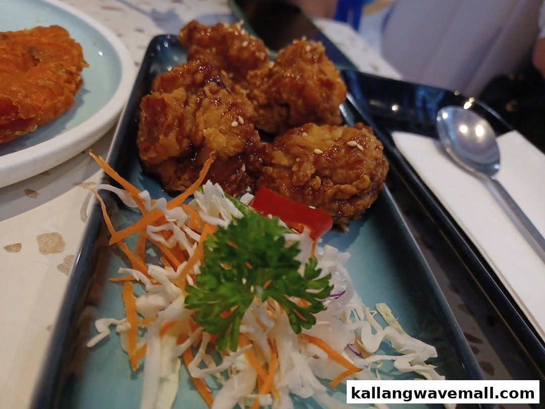 A close-up of delicious Korean fried chicken served with a fresh salad garnish.