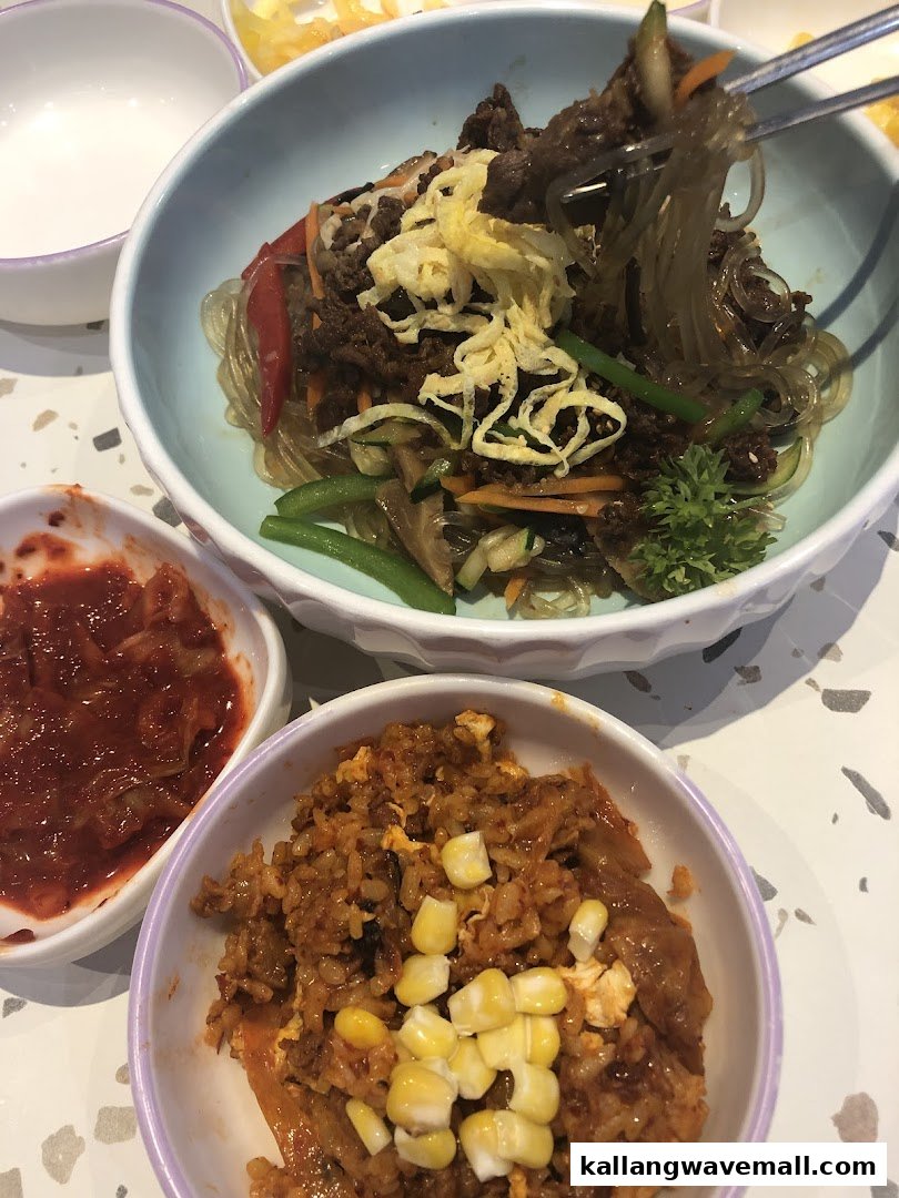 A close-up of delicious Korean japchae, kimchi fried rice, and kimchi side dish.
