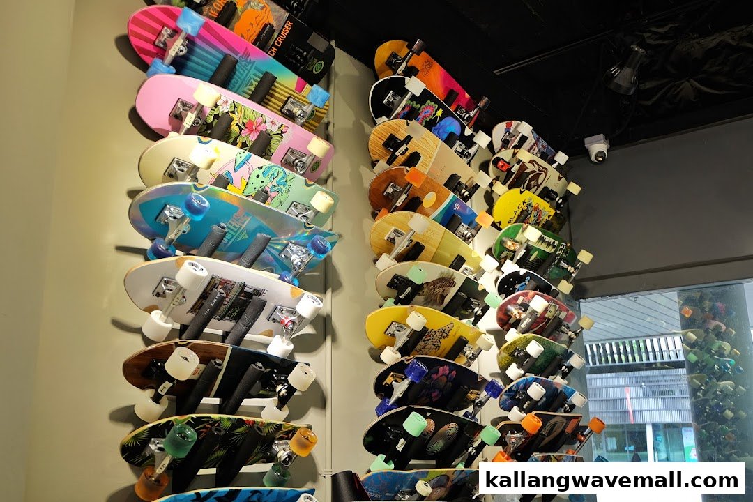 A vibrant display of numerous colorful skateboards and longboards mounted on a wall inside a retail shop.