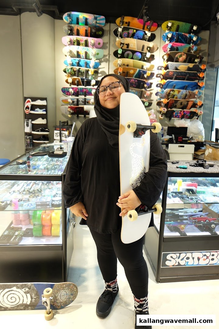 A person holds a skateboard inside a vibrant skate shop filled with various skateboards and gear.