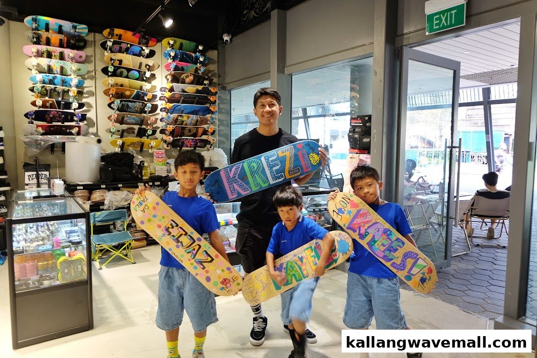 A man and three boys proudly display their custom-designed skateboards inside a vibrant skate shop.