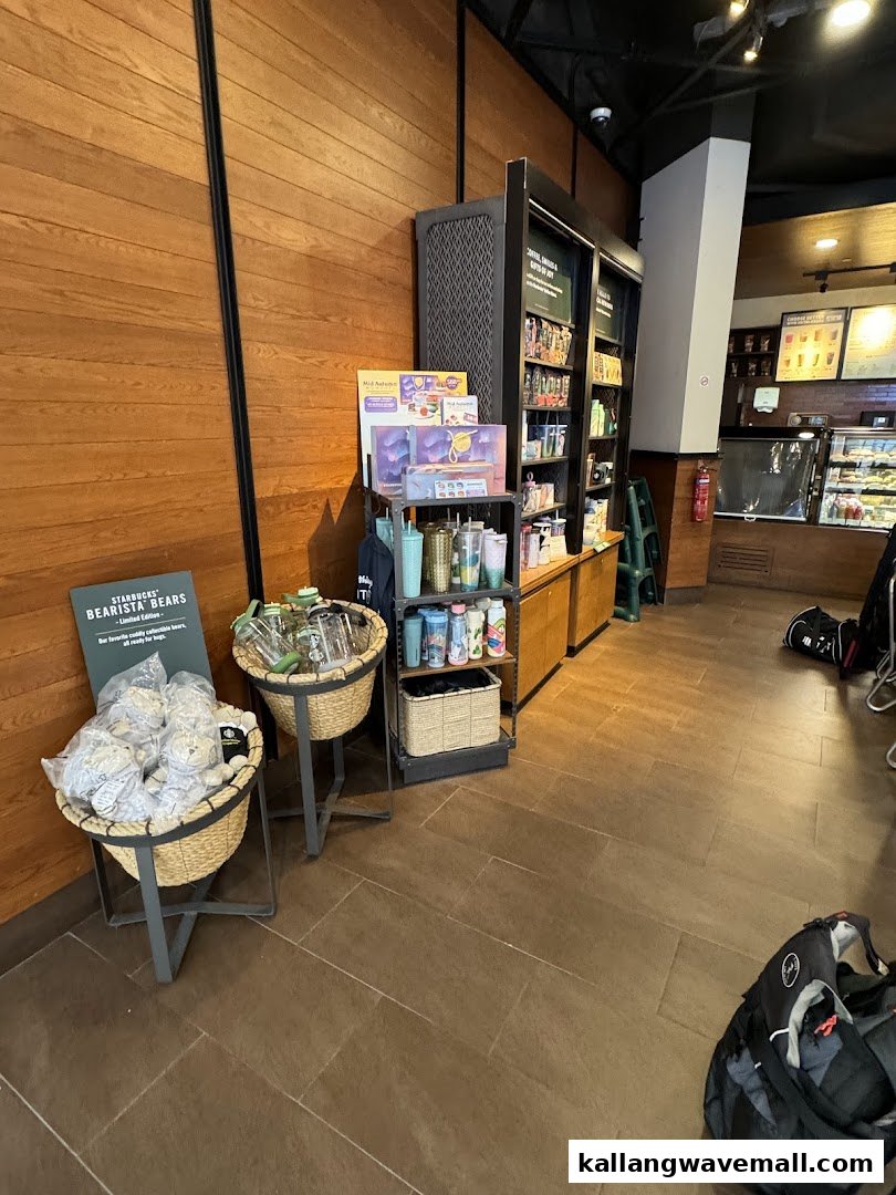 Starbucks interior with merchandise displays, including tumblers and Bearista Bears, near the counter.