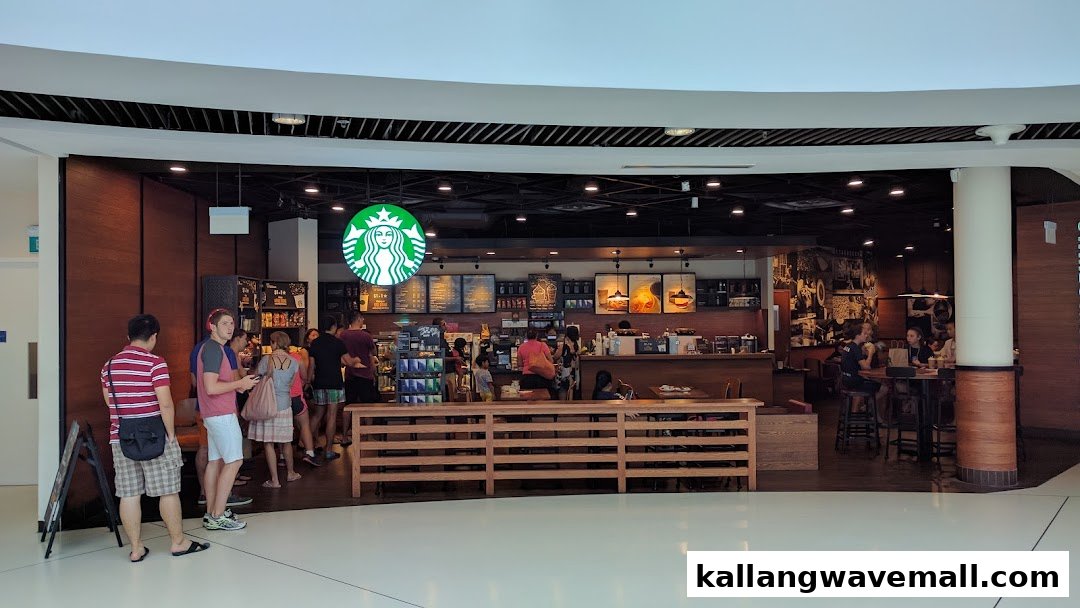 The bustling entrance of Starbucks at Kallang Wave Mall, with customers queuing and enjoying coffee.