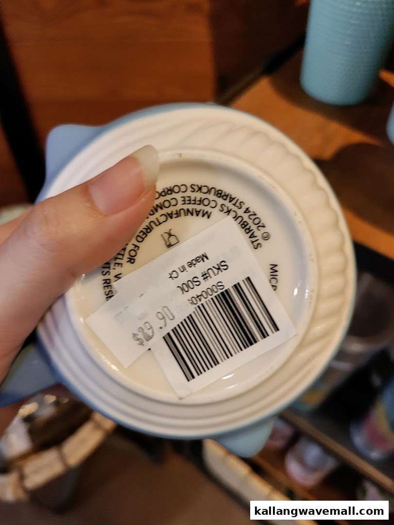 Close-up of a Starbucks mug's bottom with a price tag and manufacturing details.