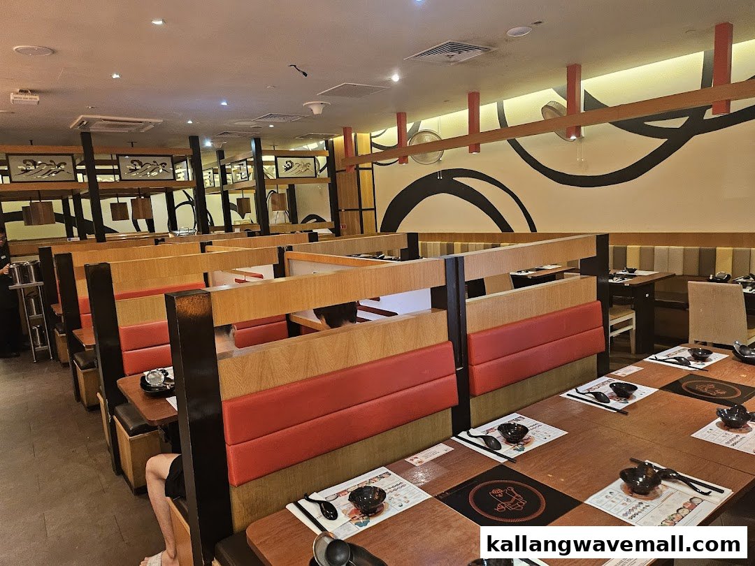 An interior view of Suki-Ya restaurant, featuring booth seating, wooden tables, and shabu-shabu cooking stations.