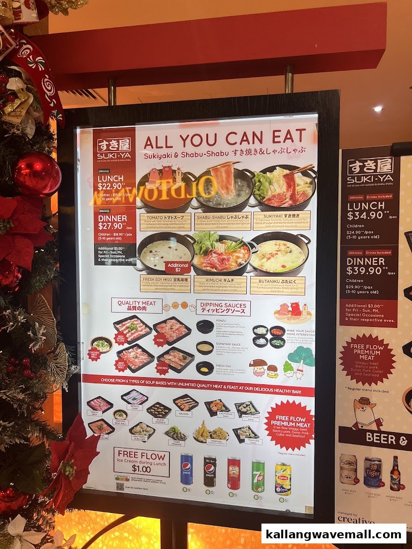 A brightly lit menu board for Suki-Ya, an all-you-can-eat shabu-shabu and sukiyaki restaurant, displaying pricing and food options.