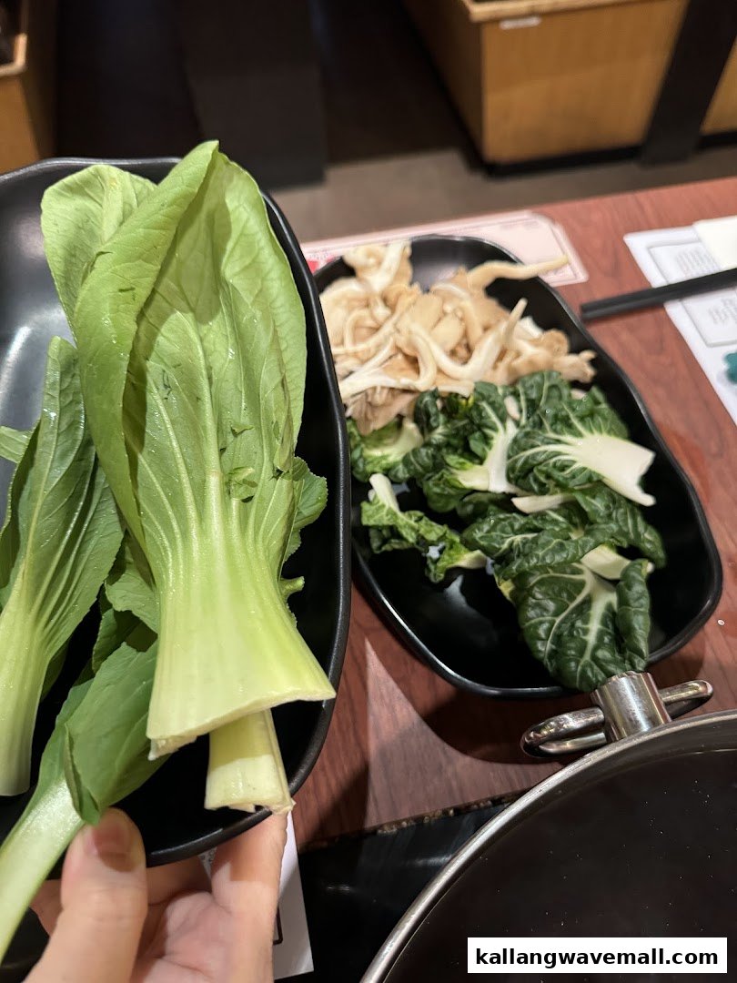 Fresh vegetables and mushrooms, including bok choy, prepared for a shabu-shabu meal.