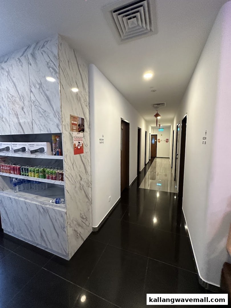 A clean, modern KTV studio hallway with private room doors and a refreshment display.