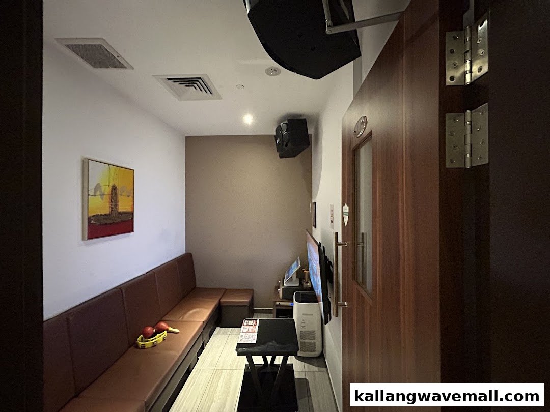 Cozy KTV room interior with comfortable seating, screen, and musical instruments.