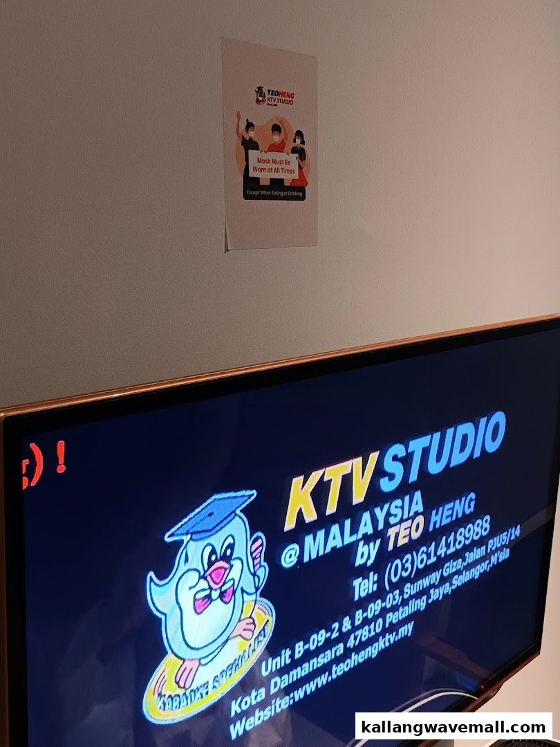 Interior view of Teo Heng KTV Studio, showing a TV screen with contact details and a mask policy poster.