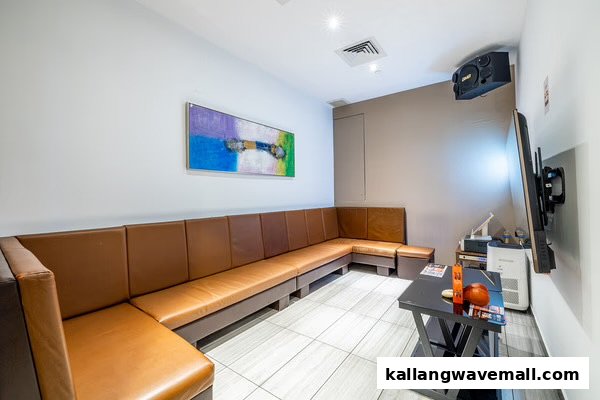 A modern KTV room with brown leather seating, a large TV, and sound system.