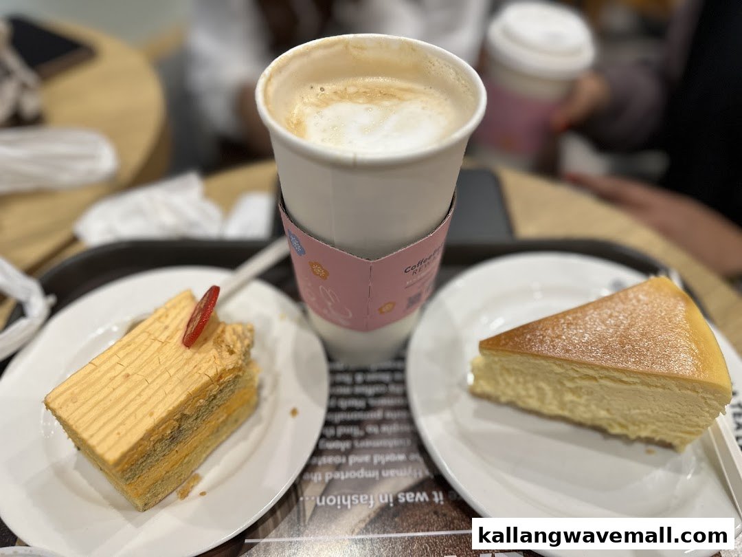 A warm coffee, a slice of cheesecake, and another cake on a table at The Coffee Bean & Tea Leaf.