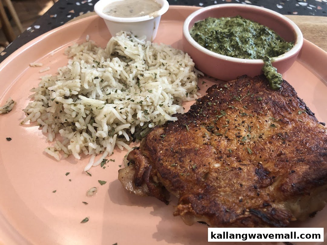 A close-up of a delicious meal featuring grilled chicken, seasoned rice, and creamy spinach.