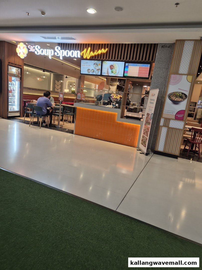 The Soup Spoon Union shop front with its bright orange counter, digital menus, and customers dining inside.