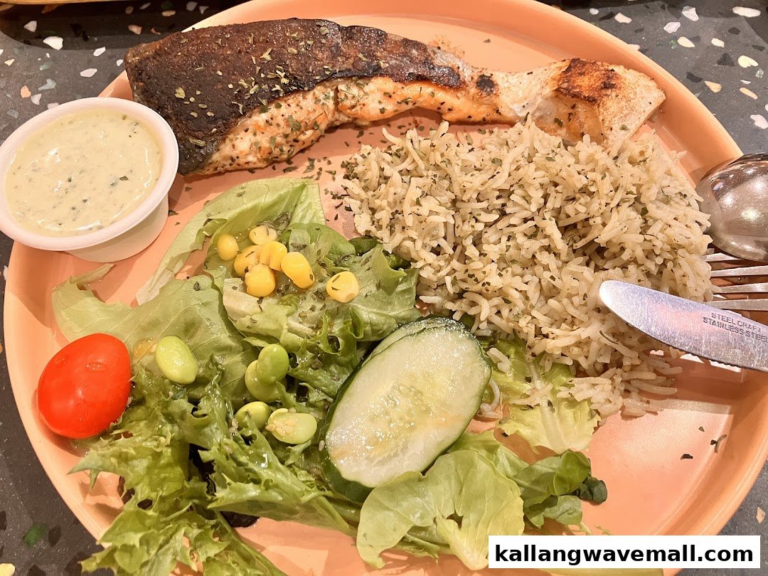 A delicious meal featuring grilled salmon, seasoned rice, fresh salad, and a creamy sauce.