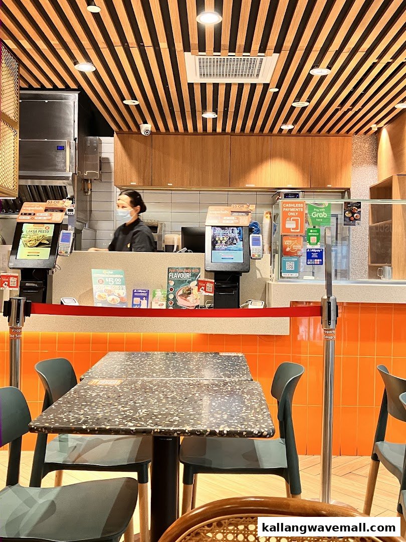 An interior view of The Soup Spoon Union, showing the service counter, a staff member, and customer seating.