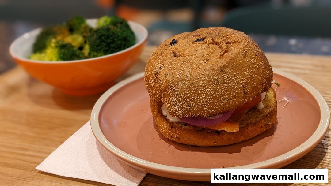 A wholesome burger with a side of steamed broccoli served on a wooden table.