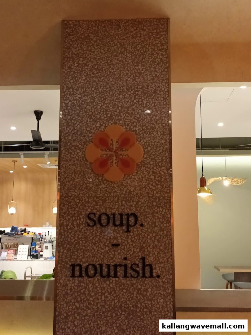 A decorative pillar inside The Soup Spoon Union featuring a floral logo and the words 'soup. nourish.'