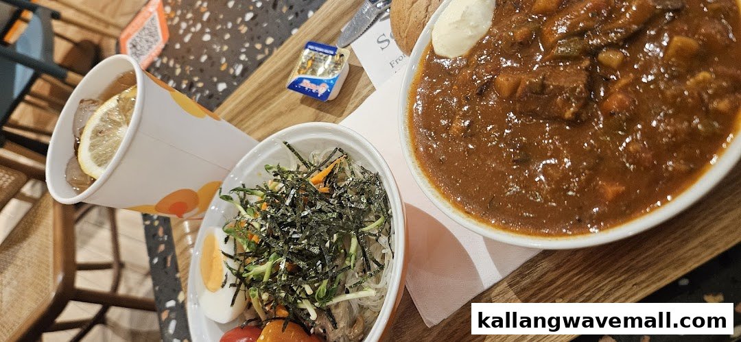 A hearty meal featuring a rich stew, a fresh salad bowl, and a refreshing lemon drink on a wooden tray.
